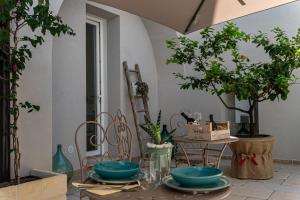 a table with plates on it with trees and plants at "Corte Tedesco" - Apulian Luxury Suites in Brindisi