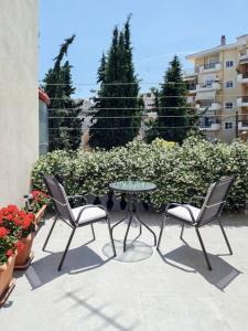 a patio with two chairs and a glass table and chairs at Garden House Retreat-Suite in Drama