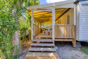 a porch with awning and stairs to a house at Bungalow in Agde