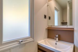 a bathroom with a sink and a mirror at Bungalow in Agde +17 photos