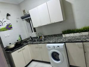 a kitchen with a washing machine and a sink at Luimora Stays in Bamgbose