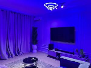 a living room with a purple room with a tv at Luimora Stays in Bamgbose +4 photos