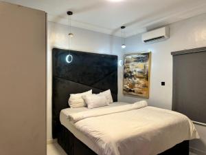 a bedroom with a large bed with a black headboard at Luimora Stays in Bamgbose