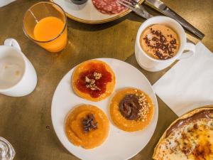 a plate with four donuts on a table with coffee at Mercure Dijon Centre Clemenceau in Dijon