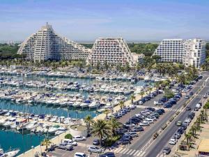 an aerial view of a marina with parked cars and buildings at Mercure Port La Grande Motte in La Grande Motte