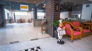 a statue of a man holding a sign in a lobby at Citin Armoni Patong Hotel by Compass Hospitality - Newly Renovated in Patong Beach +58 photos