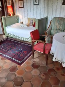 a bedroom with a bed and two chairs and a table at La ferme sympa in Droyes