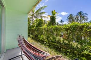 a hammock sitting on the porch of a house at Garden Balcony • Walk to Beach + Kitchen in Hilo