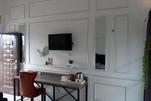a living room with a table and a tv on a wall at Kinari Sharia Living in Kediri