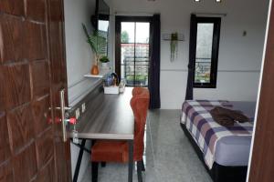 a bedroom with a desk and a bed and a table at Kinari Sharia Living in Kediri