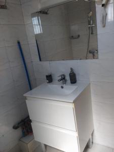 a bathroom with a white sink and a mirror at Auberge de l'hippocampe in Moroni +13 photos