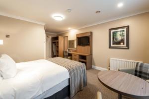 a hotel room with a bed and a table at Corr's Corner Hotel in Newtownabbey +45 photos