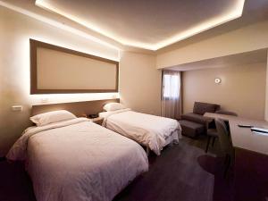 a hotel room with two beds and a chair at Beirut Hotel Cairo in Cairo