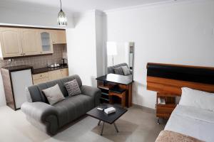 a living room with a couch and a piano at The Apartments By Sedrah in Irbid