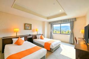 a hotel room with two beds and a window at Livemax Resort Hachimantai Forest in Hachimantai