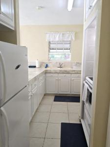 a kitchen with a white refrigerator and a window at Ocean Bliss Apartments in Christ Church