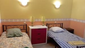 a bedroom with two beds and a dresser at Le Platane in Brioux-sur-Boutonne