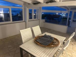 a table and chairs on a balcony at night at Apartmani Adi Tkon in Tkon