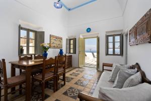 a living room with a table and chairs and a couch at Palm Tree Hill in Oia