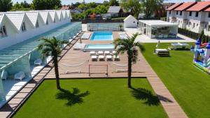 an overhead view of a swimming pool with palm trees at DESTINO wakacyjne domki-dwa podgrzewane baseny-drink bar in Mielno