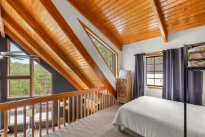 a bedroom with a bed and a balcony with windows at Spacious Flagstaff A-Frame Casita Getaway in Flagstaff