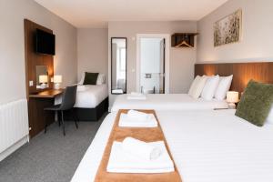 a hotel room with two beds and a desk at Coach House Accommodation - Room 5 in Carrick on Shannon