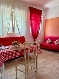 a living room with a table and a red couch at Violahouse in Bari