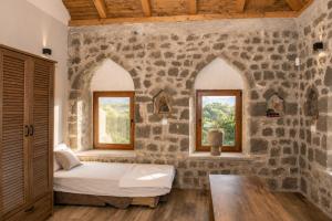 a bedroom with a bed and two windows at Villa Bilja Historic Stone Castle in Trebinje