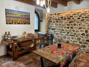 a dining room with a table and a stone wall at La Torre a colori in Esine