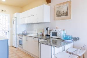a kitchen with white cabinets and a counter with a microwave at Blue Emi Altea Hills in Altea la Vieja