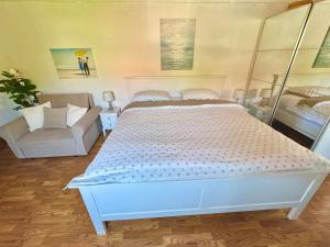 a bedroom with a large white bed and a couch at Apartments Lucy in Milna