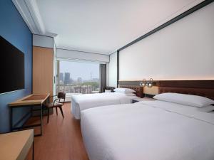 a hotel room with two beds and a large window at Four Points by Sheraton Shenzhen in Shenzhen