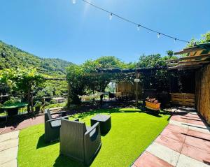 a backyard with green grass and furniture on a patio at Dimora Rosella in Tramonti