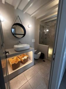 a bathroom with a sink and a mirror and a toilet at Mezzo Patmos Apartments in Patmos +23 photos