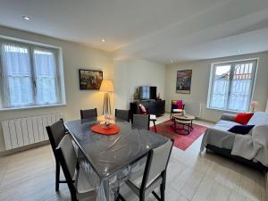a dining room and living room with a table and chairs at LE CAMELIA in Saint-Viâtre