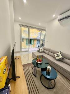 a living room with a couch and a tv and a table at Lumina Haven in Thượng Lôi