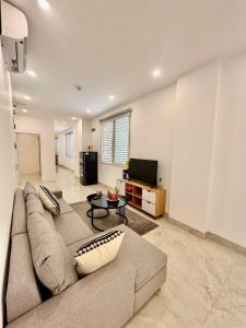 a living room with a couch and a flat screen tv at Lumina Haven in Thượng Lôi