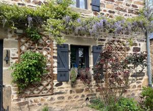 a house with purple flowers on the side of it at Gîte des vergnioux in Ayat-sur-Sioule