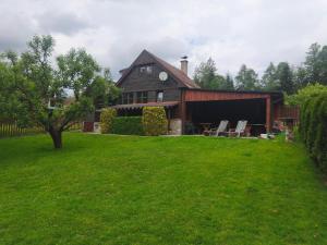a barn with two chairs in a yard at Chata Vanessa in Stránske