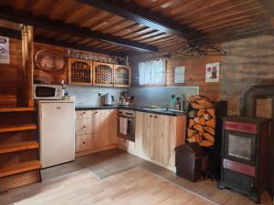 a kitchen with wooden cabinets and a stove at Chata Vanessa in Stránske