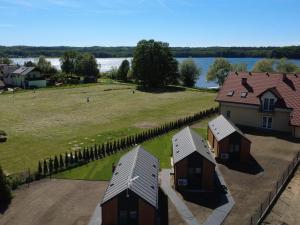 an aerial view of a house with a field and a lake at Domki Paradise Charzykowy in Charzykowy