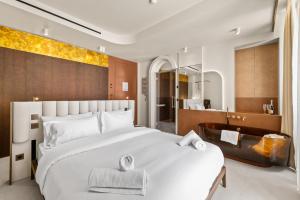 a bedroom with a large white bed and a bathroom at Naomi Cannes in Cannes