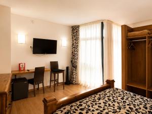 a hotel room with a bed and a desk and a television at Hotel Boa Vila in Pontevedra
