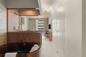 a bathroom with a tub in the middle of a room at Naomi Cannes in Cannes