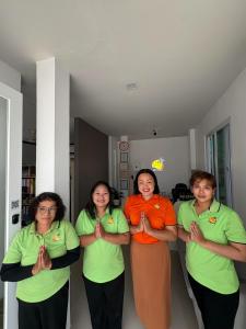 a group of four women standing in a room praying at Kata Beachwalk Hotel and Bungalows in Kata Beach