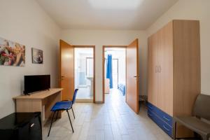 a room with a desk and a tv and a chair at Giostemar Rooms - Playa Grande in Scicli