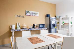 a kitchen with a counter with two tables and a refrigerator at Giostemar Rooms - Playa Grande in Scicli
