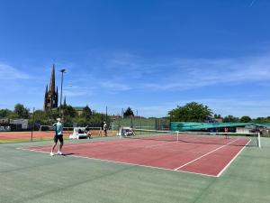 a man is standing on a tennis court at La Cordillière in Laveraët