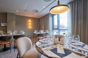 a dining room with tables and chairs with wine glasses at Frich`s Hotel Surnadal in Surnadal