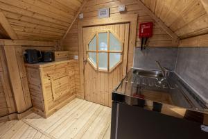 a kitchen with a stove and a sink in a cabin at Caerketton Cabin in Kirknewton +12 photos